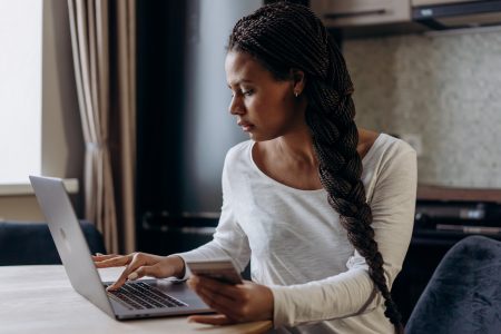 Woman on laptop holding credit card