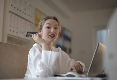 Teenage girl with bank card shopping online